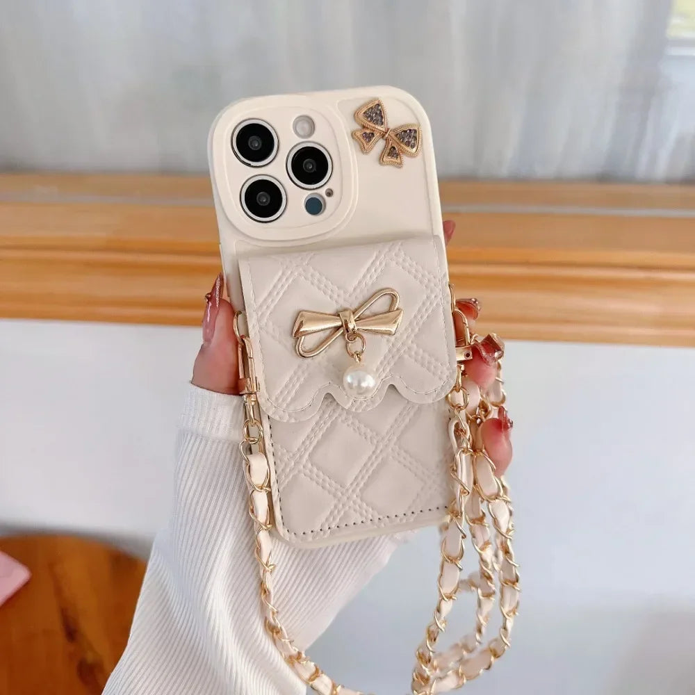 Phone case with bow design and chain strap held by a hand