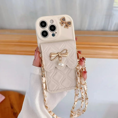 Phone case with bow design and chain strap held by a hand