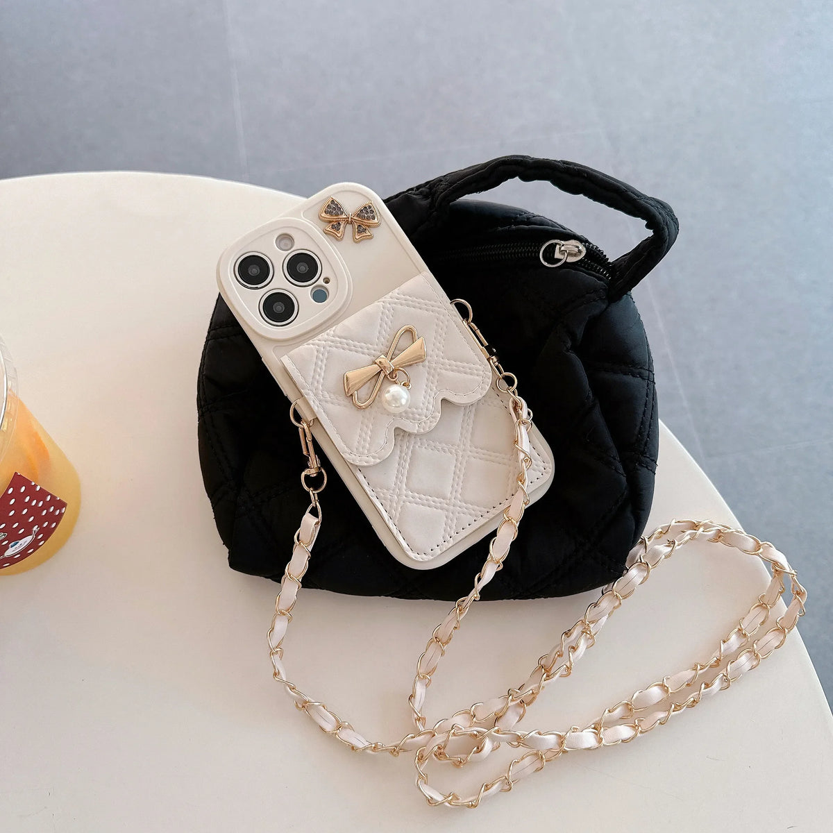 Phone case with decorative chain on a light gray background